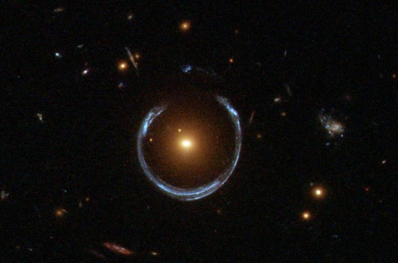 imagen 2: efecto de lente gravitatoria. el círculo que envuelve el objeto central no es más que la imagen de una o varias galaxias situadas detrás de este objeto. al pasar la luz de estas galaxias por la zona de influencia del objeto, esta se desvía por acción de la gravedad. el efecto es igual al de las lentes que todos utilizamos.