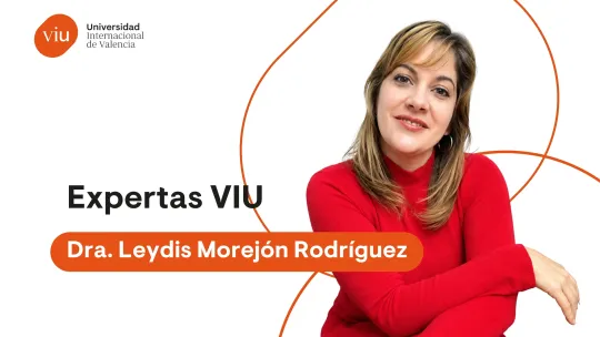 Retrato de la Dra. Leydis Morejón con un vestido rojo y los brazos cruzados, sobre un fondo blanco con formas geométricas naranjas