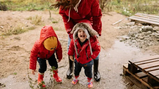 profesora-y-dos-ninos-jugando-bajo-la-lluvia-aprendiendo-mediante-aprendizaje-incidental
