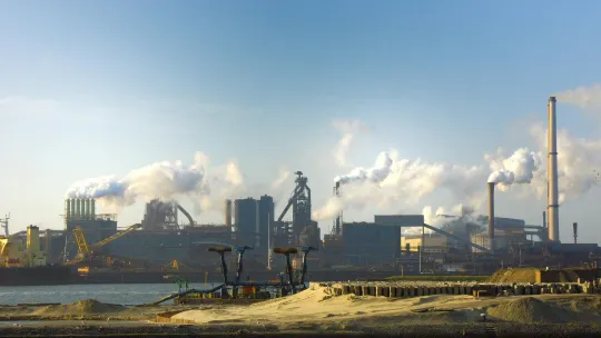 chimeneas-de-una-industria-lanzando-emisiones-visibles-simbolo-de-como-afecta-el-cambio-climatico-al-ser-humano