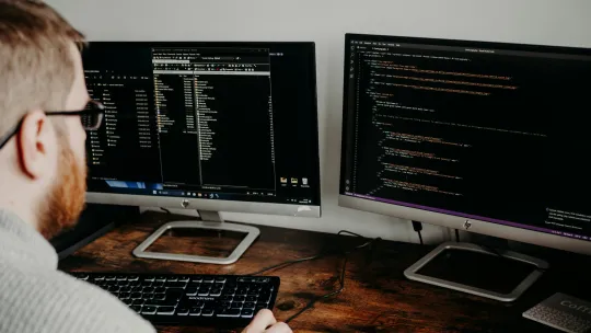 data-scientist-viu persona-programando-en-dos-pantallas-mientras-trabaja-como-data-scientist