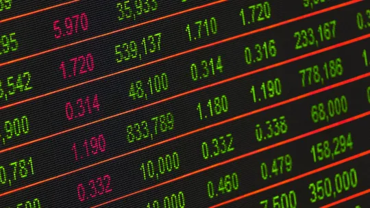 Registro digital de métricas financieras y datos masivos Pantalla de panel electrónico con filas de cifras numéricas en verde y rojo sobre fondo oscuro, representando el análisis numérico y la gestión de datos masivos.