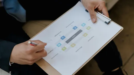 mano-de-un-directivo-escolar-analizando-un-diagrama-sobre-la-gestion-educativa