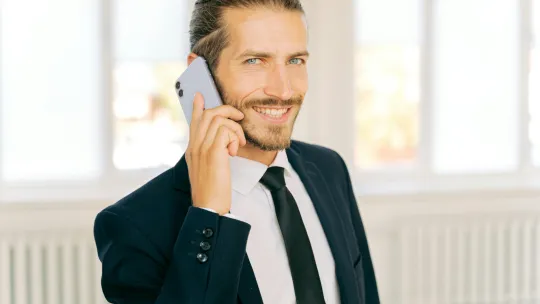 hombre-joven-con-traje-hablando-por-telefono-como-ejemplo-de-habilidades-directivas