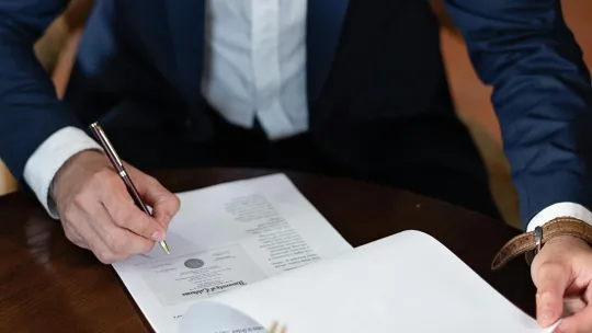 hombre-firmando-documento-relacionado-con-la-ley-de-patentes