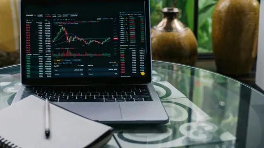 portatil-sobre-mesa-con-graficos-de-inversiones-para-ilustrar-master-en-finanzas-o-mba-online