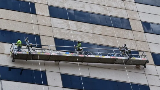 operarios-trabajando-en-un-andamio-de-un-edificio-siguiendo-las-indicaciones-de-un-prevencionista-de-riesgos