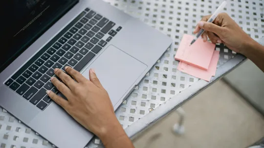 reciclaje-profesional-viu persona-escribiendo-en-notas-adhesivas-mientras-trabaja-en-un-portatil-sobre-reciclaje-profesional