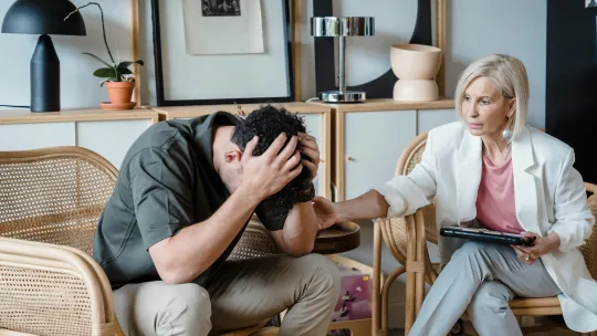 Sesión de terapia entre un paciente y una profesional de la psicología