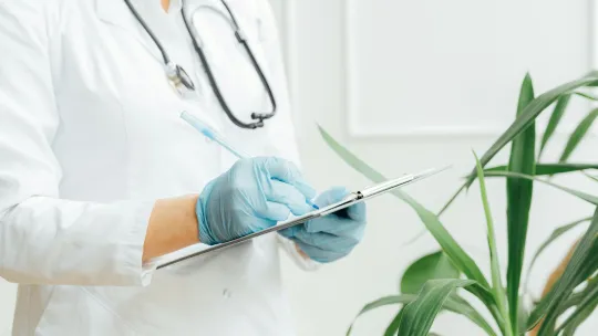 doctora-escribiendo-en-un-portapapeles-como-parte-del-sistema-de-gestion-hospitalaria