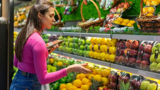 mujer-eligiendo-frutas-en-un-supermercado-representando-tipos-de-consumidores
