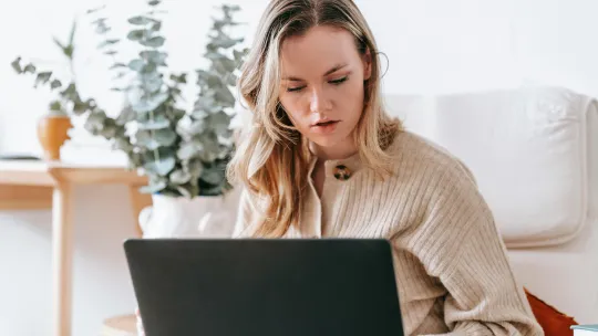 una-mujer-estudia-desde-un-ordenador-portatil-aprendiendo-sobre-upskilling-y-reskilling-en-su-hogar