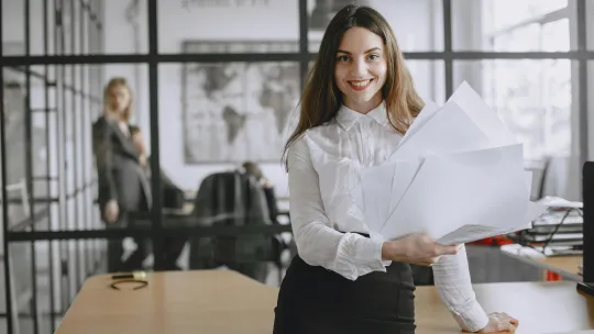 mujer-sonriente-en-una-oficina-con-documentos-que-representa-la-vocacion-psicologo