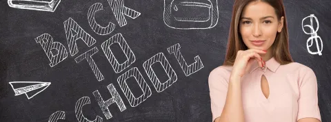 profesora-apoyada-en-una-pizarra-como-ejemplo-de-docente-que-cumple-con-las-competencias-profesionales