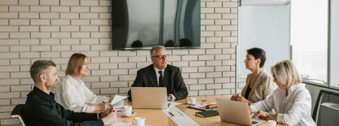 grupo-de-profesionales-en-una-reunion-de-negocios-liderada-por-un-hombre-que-pasa-de-perfil-tecnico-a-directivo