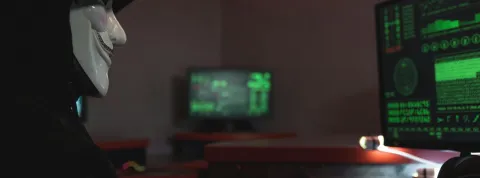 hacker-con-mascara-frente-a-computador-ilustrando-los-delitos-informaticos-en-colombia