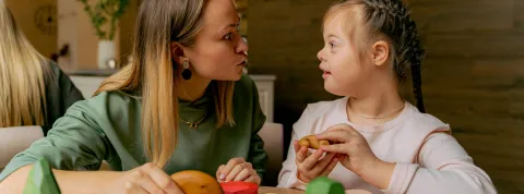 mujer-jugando-con-nina-con-discapacidad-como-parte-de-un-programa-de-educacion-especial