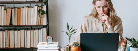 mujer-trabajando-sentada-en-un-despacho-con-un-ordenador-que-esta-sobre-un-escritorio-ejemplo-de-emprendimiento-digital