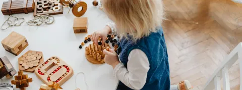 niña-pequeña-jugando-con-juguetes-de-madera-como-parte-de-la-estimulacion-temprana-en-ecuador