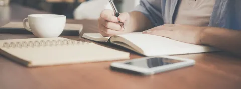 persona-escribiendo-en-una-libreta-como-simbolo-de-estudiar-traduccion-e-interpretacion