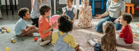 aula-con-alumnos-una-profesora-y-un-psicopedagogo-todos-sentados-en-el-suelo-donde-este-esta-hablando-al-resto