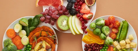 platos-con-frutas-y-verduras-frescas-que-representan-la-funcion-de-la-nutricion-en-una-dieta-equilibrada