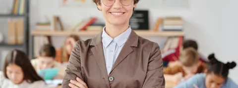 una-profesora-posa-con-los-brazos-cruzados-mostrando-habilidades-blandas-como-paciencia-empatía-y-comunicación-en-el-aula