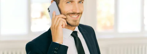 hombre-joven-con-traje-hablando-por-telefono-como-ejemplo-de-habilidades-directivas