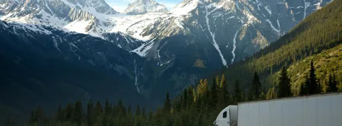 camion-de-carga-transitando-por-carretera-en-medio-de-montanas-como-representacion-de-la-logistica-y-transporte