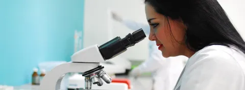 cientifica-en-un-laboratorio-mirando-por-un-microscopio-llevando-a-cabo-una-observacion-no-participante