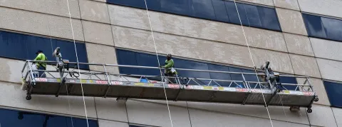 operarios-trabajando-en-un-andamio-de-un-edificio-siguiendo-las-indicaciones-de-un-prevencionista-de-riesgos
