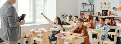 docente-frente-a-un-grupo-de-estudiantes-en-clase-donde-hablan-sobre-la-psicoeducacion