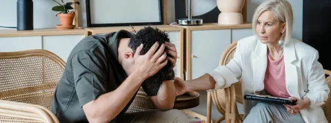 hombre-en-sesion-de-terapia-con-una-profesional-que-cumple-los-requisitos-para-ser-psicologo-general-sanitario