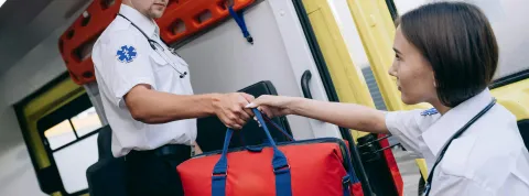 dos-sanitarios-en-una-ambulancia-y-uno-le-esta-dando-una-bolsa-a-otro-realizando-una-buena-labor-de-salud-comunitaria-en-peru