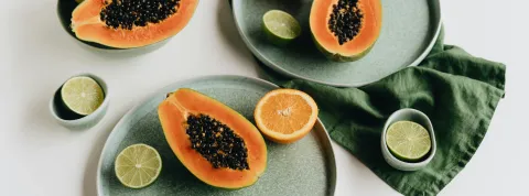 rodajas-de-papaya-naranja-y-limon-sobre-platos-verdes-como-representacion-de-una-alimentacion-balanceada-para-la-salud-nutricional