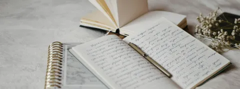 cuadernos-abiertos-sobre-una-cama-que-representan-la-vocacion-de-ser-escritor-en-colombia