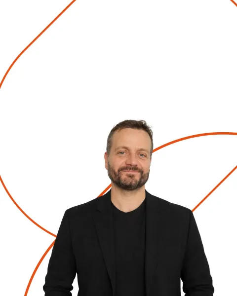 retrato de medio cuerpo de Roberto García Velado, experto VIU. Viste de negro y está recortado sobre un fondo blanco con formas geométricas naranjas