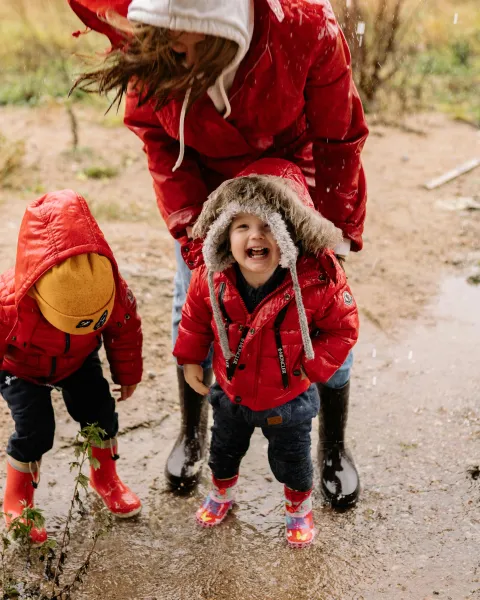 profesora-y-dos-ninos-jugando-bajo-la-lluvia-aprendiendo-mediante-aprendizaje-incidental