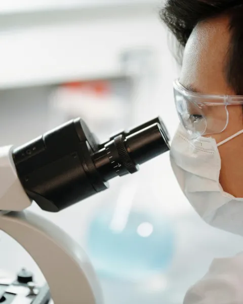 estudiante-de-ciencias-forenses-en-un-laboratorio-mirando-por-un-microscopio