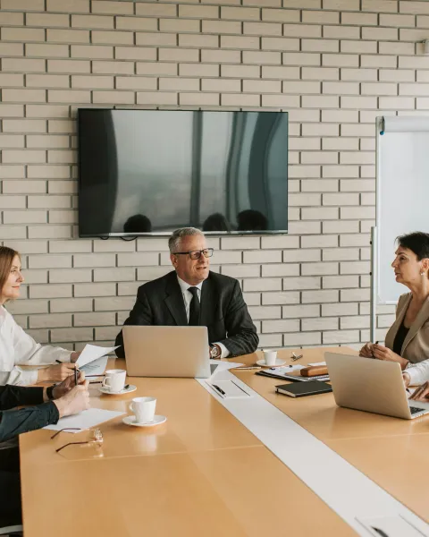 grupo-de-profesionales-en-una-reunion-de-negocios-liderada-por-un-hombre-que-pasa-de-perfil-tecnico-a-directivo