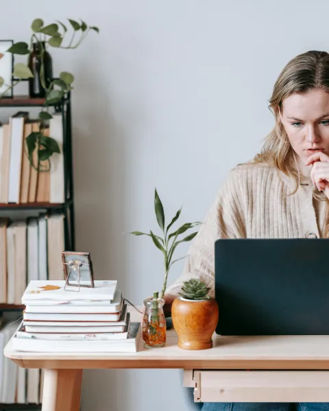 mujer-trabajando-sentada-en-un-despacho-con-un-ordenador-que-esta-sobre-un-escritorio-ejemplo-de-emprendimiento-digital