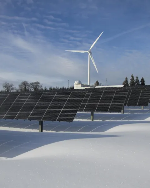 campo-de-paneles-solares-fotovoltaicos-y-aerogenerador-eolico-en-un-paisaje-nevado-potenciando-las-energias-renovables