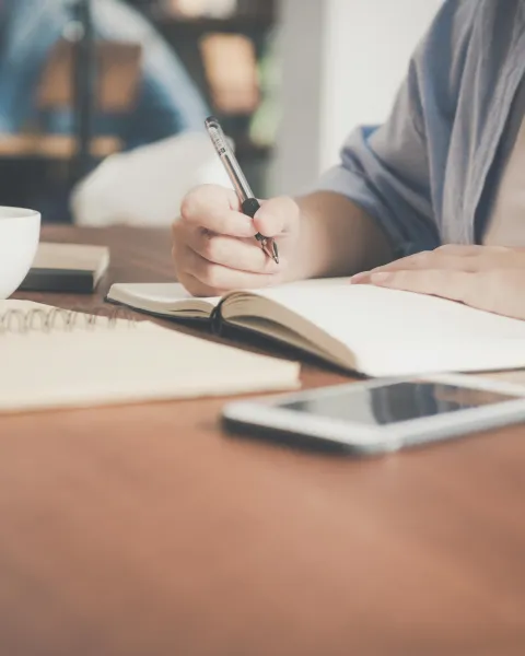 persona-escribiendo-en-una-libreta-como-simbolo-de-estudiar-traduccion-e-interpretacion