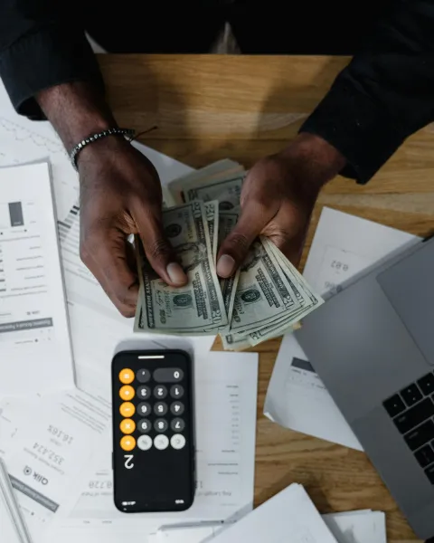 persona-contando-dinero-sobre-documentos-financieros-como-parte-de-la-gestion-financiera-en-colombia
