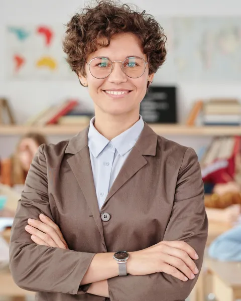 una-profesora-posa-con-los-brazos-cruzados-mostrando-habilidades-blandas-como-paciencia-empatía-y-comunicación-en-el-aula