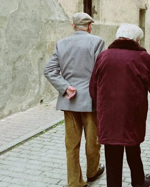 Hombre y mujer caminando cerca de una puerta de madera cerrada - @pzlvrs en Unsplash