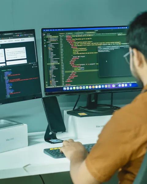 programador-trabajando-con-codigo-y-pantallas-mientras-cursa-un-master-en-ia-online