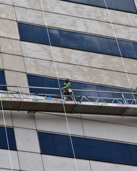 operarios-trabajando-en-un-andamio-de-un-edificio-siguiendo-las-indicaciones-de-un-prevencionista-de-riesgos