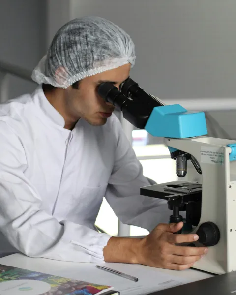 profesional-mirando-por-un-microscopio-trabajando-en-un-laboratorio-una-de-las-ramas-de-la-biologia