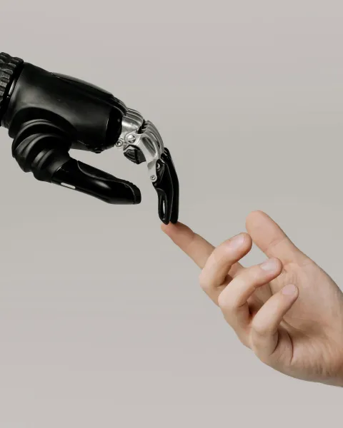 mano-de-hombre-y-mano-de-robot-uniendo-el-indice-como-simbolo-de-los-usos-de-la-inteligencia-artificial-en-la-vida